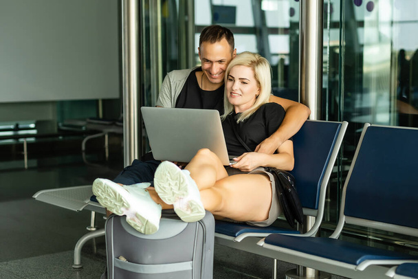 Smart working and digital nomad. alternative eveywhere office concept with couple of caucasian people use phones device and laptop computer during fly travel in airport. - Photo, Image