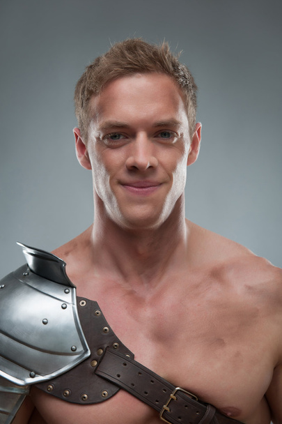 Closeup portrait of Gladiator in armour over grey background - Photo, Image