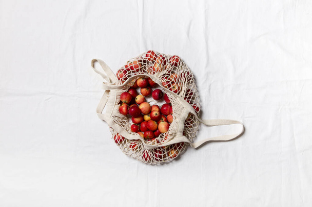 red apples with a cup and a basket of dried fruits on a white table - Foto, Bild