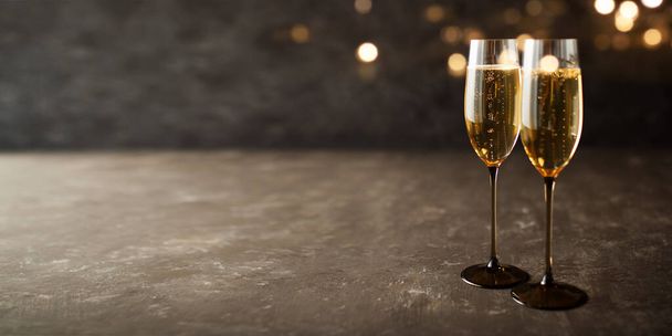 Two glasses with champagne on old stone plate and golden bokeh - Foto, immagini