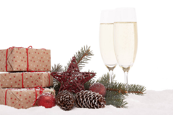 Still life with champagne bottle standing in a bucket with ice, two full champagne flutes, gift box and Christmas ornaments. Christmas and New Year  background.  Greeting card - Фото, зображення