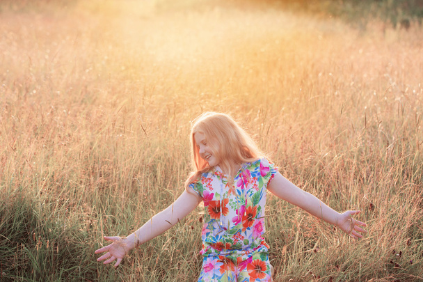 happy girl on meadow at sunset - Foto, Imagen