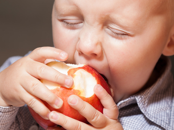 Little boy eating apple fruit at home - Фото, зображення