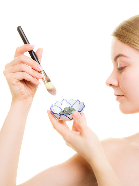 Woman applying clay mud mask on face - Photo, Image