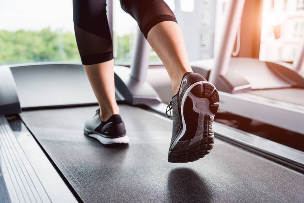 young woman running on treadmill in gym - Photo, image