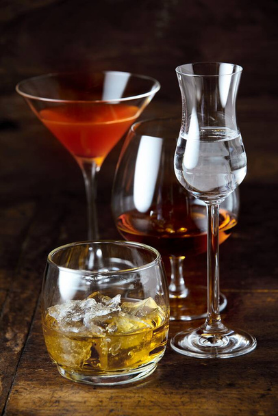 Stylish glasses of poured whisky, cognac, martini and liqueur on a pub or nightclub counter in vertical format - Valokuva, kuva