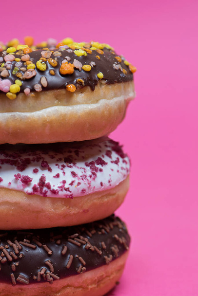 Macro shot of stack of donuts over pink background - Foto, Imagen