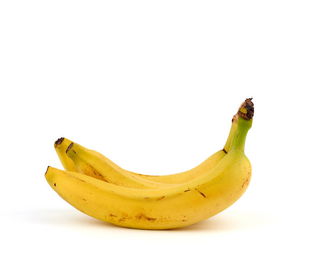 rijpe gele bananen in een schil op een witte achtergrond, close up - Foto, afbeelding