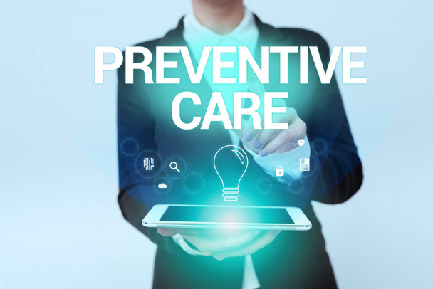 Handwriting text Preventive Care. Business overview care that you receive to prevent illnesses or diseases Woman In Uniform Holding Mobile Phone Showing Futuristic Virtual Icons - Photo, Image