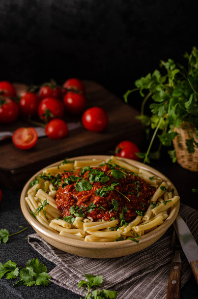 pasta with tomato sauce and basil on a dark background. selective focus. - Foto, Imagem