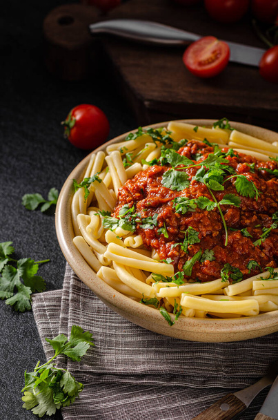 pasta with tomato sauce and basil leaves on wooden background - Fotografie, Obrázek
