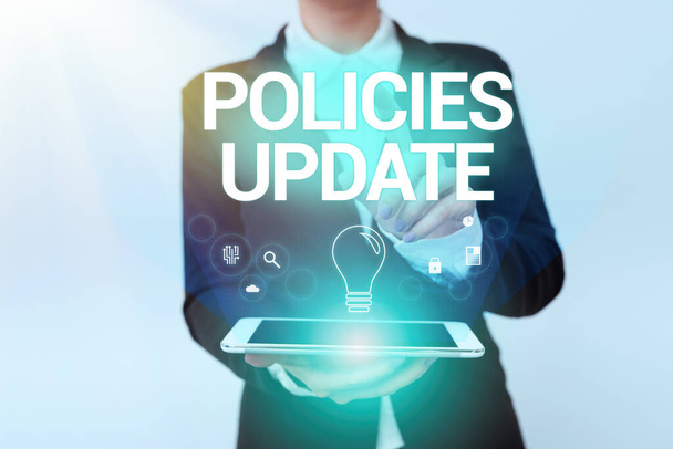 Writing displaying text Policies Update. Business idea act of adding new information or guidelines formulated Woman In Uniform Holding Mobile Phone Showing Futuristic Virtual Icons - Photo, Image