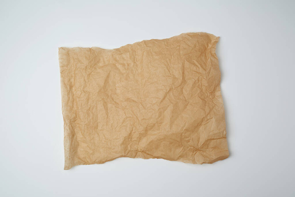 torn brown pieces of parchment paper on a white background, flat lay - Фото, изображение