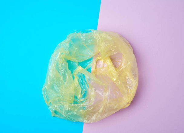 open empty plastic bag for products on a colored background, concept of rejection of plastic bags to save the environment - Фото, зображення