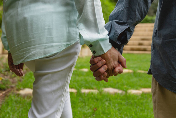 Closed-up of active senior Caucasian couple standing together hand in hand at garden - Foto, immagini