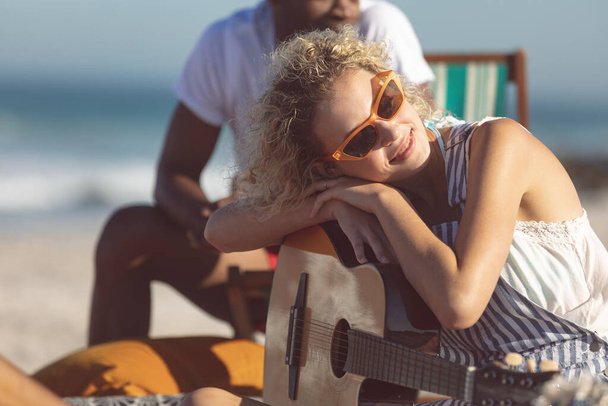 young couple enjoying music on beach - Fotó, kép