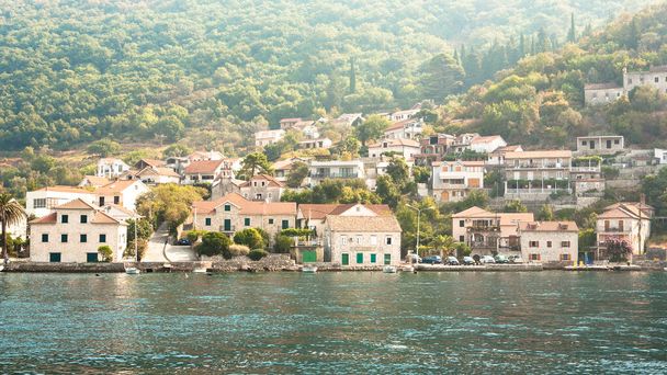 Hermoso paisaje marino mediterráneo con casas cubiertas de azulejos en el fondo de las montañas en un día soleado. Concepto italiano de paisaje marino. Viajar en barco - Foto, imagen