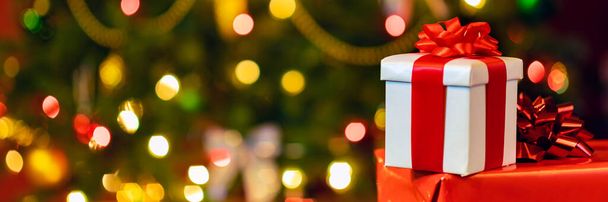 gift boxes with ribbon and bow on holiday lights background - Fotografie, Obrázek