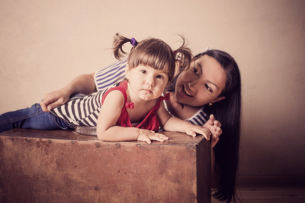 little girl and mother with old suitcase indoor - Φωτογραφία, εικόνα