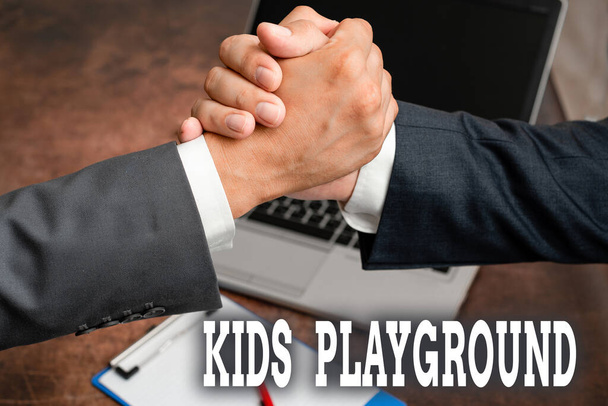 Text showing inspiration Kids Playground. Business concept piece of land designed for children to play in outside Two Professional Well-Dressed Corporate Businessmen Handshake Indoors - Photo, Image