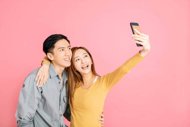 Cheerful young couple taking selfie with  the smart phone - Foto, imagen