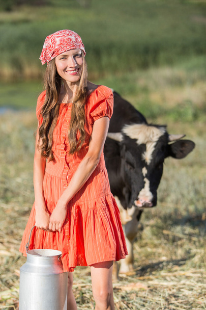 Smiling young farmer carrying fresh milk - Foto, imagen