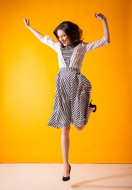 Smiling woman in beautiful dress posing at studio - Фото, изображение