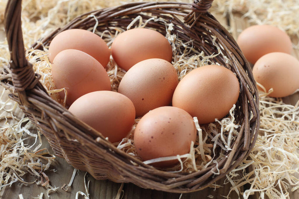 eggs in a basket on a wooden background - Fotografie, Obrázek