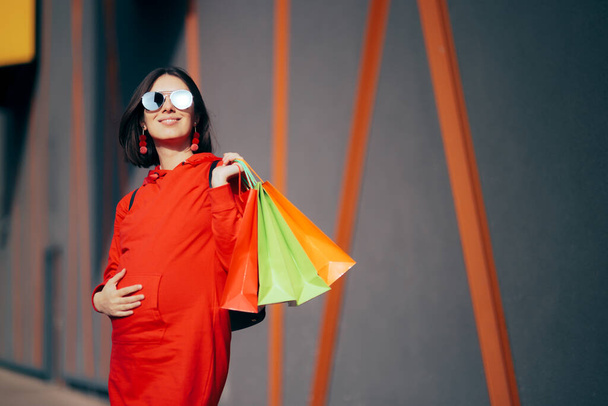 Donna incinta alla moda che tiene borse colorate per la spesa - Foto, immagini