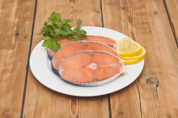 filete de salmón crudo en plato blanco sobre mesa de madera
 - Foto, imagen