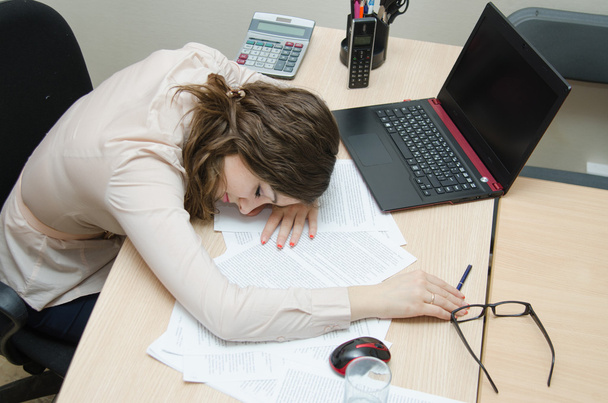 Tired woman asleep on a workplace at office - Fotó, kép