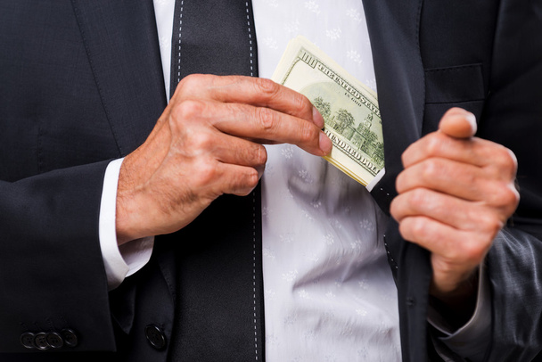 Businessmen hiding money to his pocket - Фото, зображення