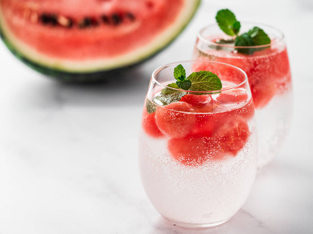 Watermelon ice with sparkling water or soda in glass tumbler. Summer party idea and recipe, add color and flavor for soda or other drink. Copy space. White marble background - Zdjęcie, obraz