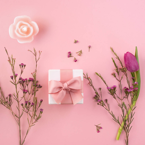 Romantic flat lay flower decoration with small gift. Square pink background for a mother's day or birthday concept with space for text and design. - Fotografie, Obrázek