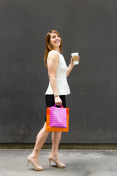 vrouw met shopping tassen en koffie in de stad - Foto, afbeelding