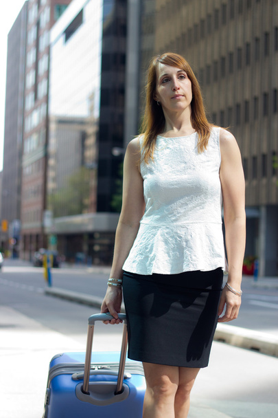 Business woman walking downtown with a suitcase - Zdjęcie, obraz