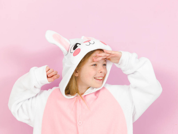 pretty blonde girl with cozy rabbit costume is posing in the studio - Фото, изображение