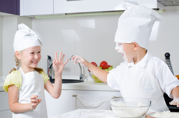 Onnellinen pieni poika ja tyttö leipoo keittiössä
 - Valokuva, kuva