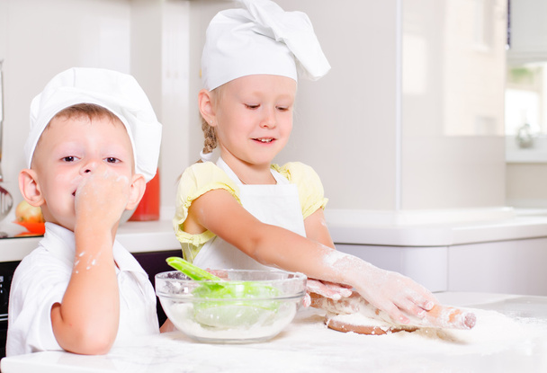 Two happy young children learning to bake - Photo, Image