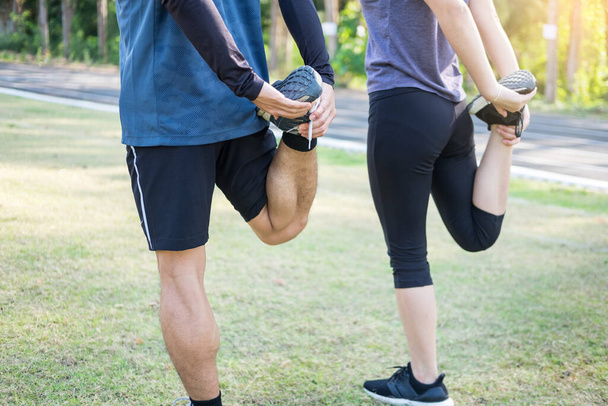 Early morning workout, Fitness couple stretching outdoors in park. Young man and woman exercising together in morning, Relationship healthy lifestyle fitness, sport concept - Фото, зображення