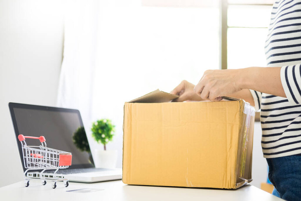 e-commerce delivery concept and online selling start up small business owner packing in the card box at workplace. freelance woman seller prepare product for packaging process at shop. - Φωτογραφία, εικόνα