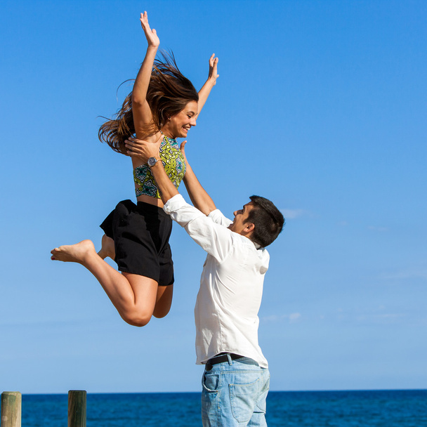 Tyttö hyppää poikien syliin
 - Valokuva, kuva