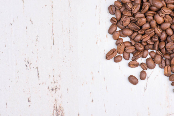 Roasted coffee beans on a white textured wooden background, empty copy space for text - 写真・画像