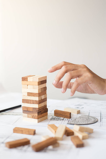 Planning, risk and strategy in business, businessman and engineer gambling placing wooden block on a tower - Photo, Image
