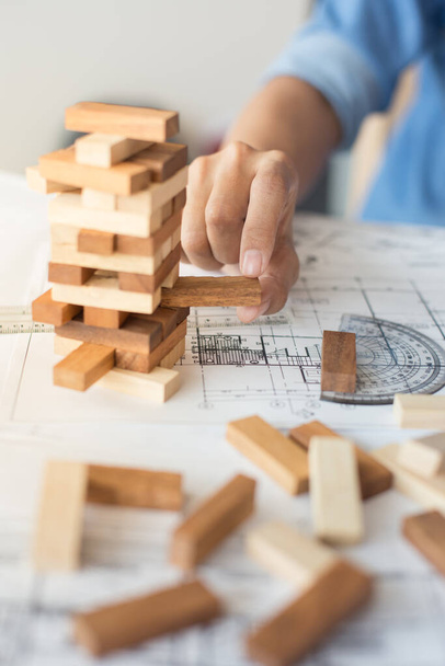 Planning, risk and strategy in business, businessman and engineer gambling placing wooden block on a tower - Фото, изображение