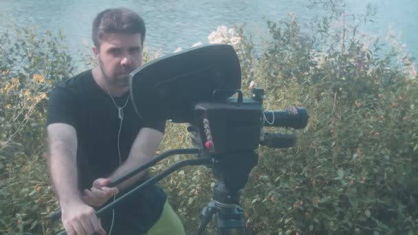 muž pomocí filmové kamery venku - Záběry, video
