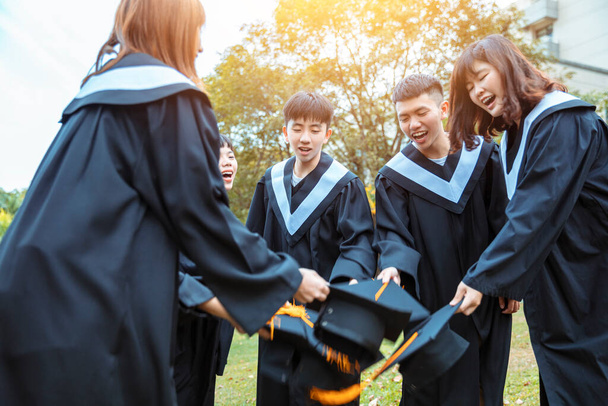 happy  students in graduation gowns celebrating in university campus - Фото, зображення