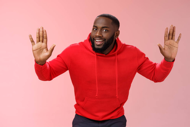 Boldog bájos kimenő afro-amerikai férfi modell emelje fel a kezét vicc álló megadás mosolygós feladni barátnő nyert vigyorog menni vacsora étterem, álló rózsaszín háttér - Fotó, kép