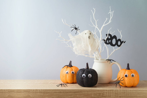 Halloween holiday decorations with glitter pumpkin, spiders and ghost on wooden table. - Photo, Image
