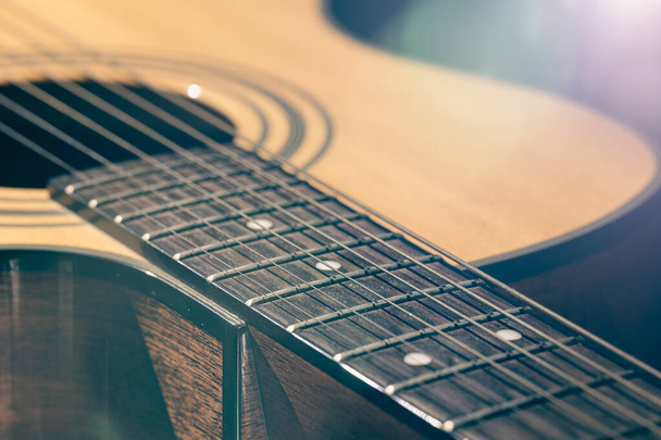 Частина акустичної гітари, гітарна дошка з струнами на чорному тлі з підсвічуванням
. - Фото, зображення